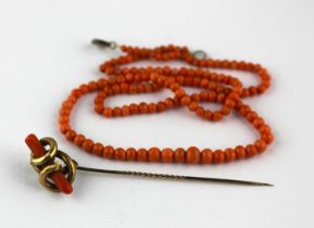A Victorian coral stick pin and a single row necklace of graduated coral beads