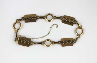 A gold bracelet in a rectangular and circular link design with engine turned decoration, on a snap