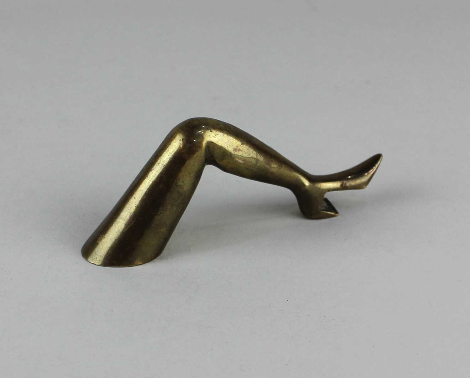 A brass novelty bottle opener in the form of a lady's leg