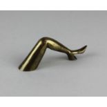 A brass novelty bottle opener in the form of a lady's leg