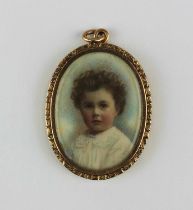 A gold mounted oval pendant locket glazed with a colour tinted photographic portrait of children