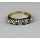 A gold and diamond five stone ring mounted with a row of graduated principal cushion shaped diamonds