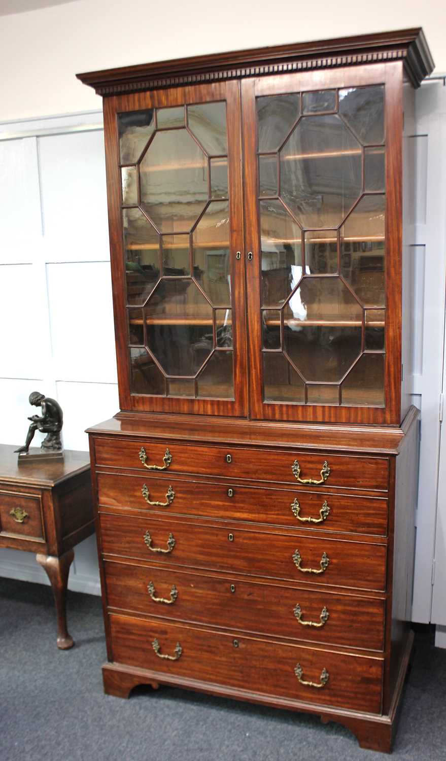 A George III mahogany secretaire bookcase with dentil carved cornice, two panel glazed doors