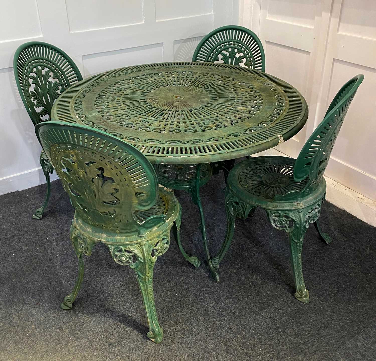 A green painted metal circular garden table and four matching chairs, diameter 104cm