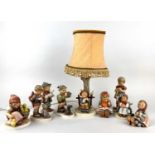 A collection of eight various Goebel porcelain figures of children and a Goebel table lamp (a/f)