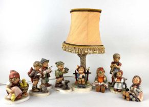 A collection of eight various Goebel porcelain figures of children and a Goebel table lamp (a/f)