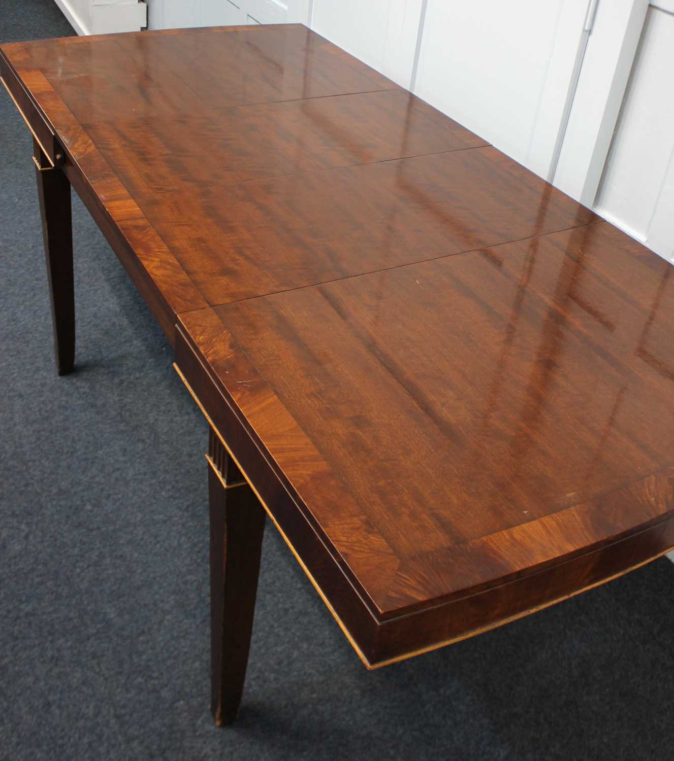 An Edwardian mahogany two leaf extending dining table, the crossbanded shaped rectangular top on - Image 2 of 2