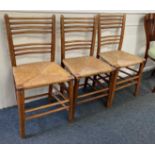 Three ladderback dining chairs with rush seats