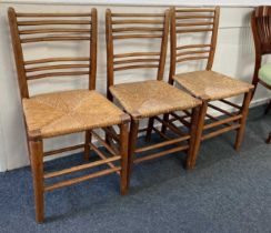 Three ladderback dining chairs with rush seats