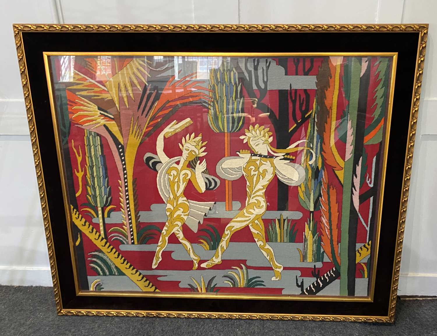 A mid 20th century woven wool tapestry panel of dancing pan figures in a woody glade c.1940, in gilt