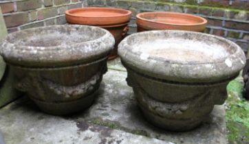 A pair of composite stone garden planters with swagged decoration 49cm diameter
