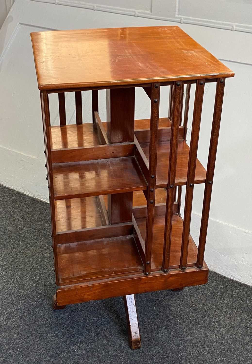 A small mahogany revolving bookstand with square top and slatted sides, 38cm