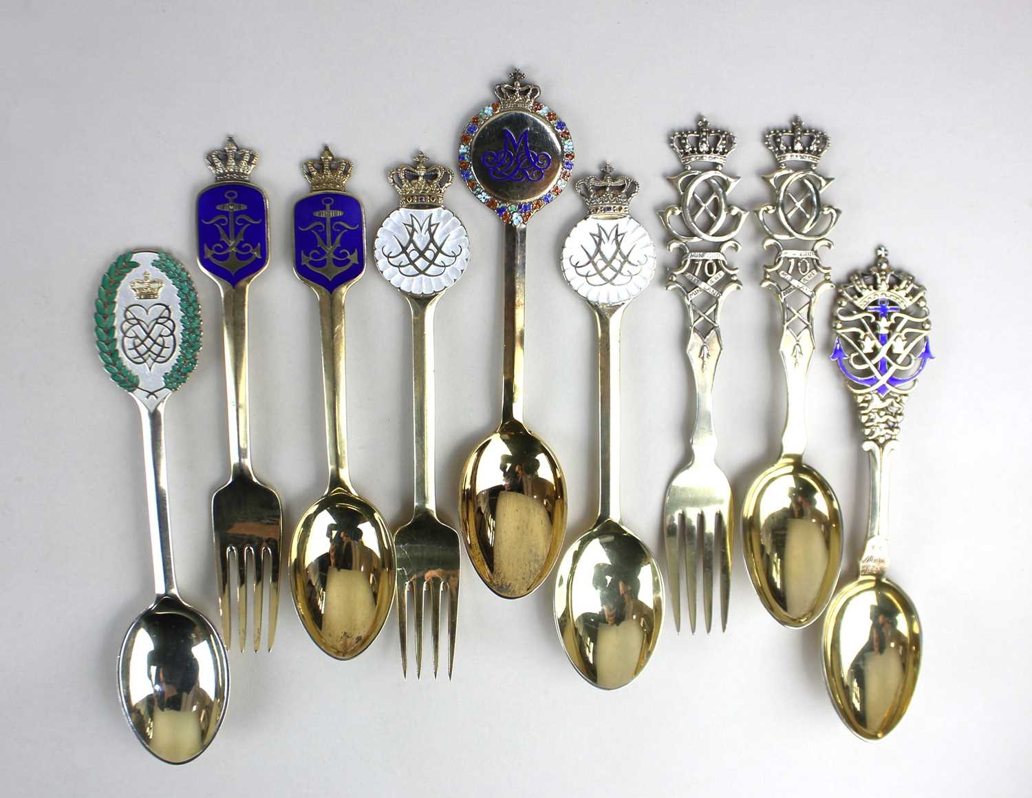 A collection of nine Danish enamelled silver-gilt Royal Commemorative spoons, including examples
