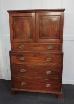 A George III mahogany cabinet on chest the top section with two panelled cupboard doors and drawer