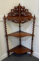 A Victorian rosewood three-tier corner whatnot with pierced surmount on spiral turned supports,