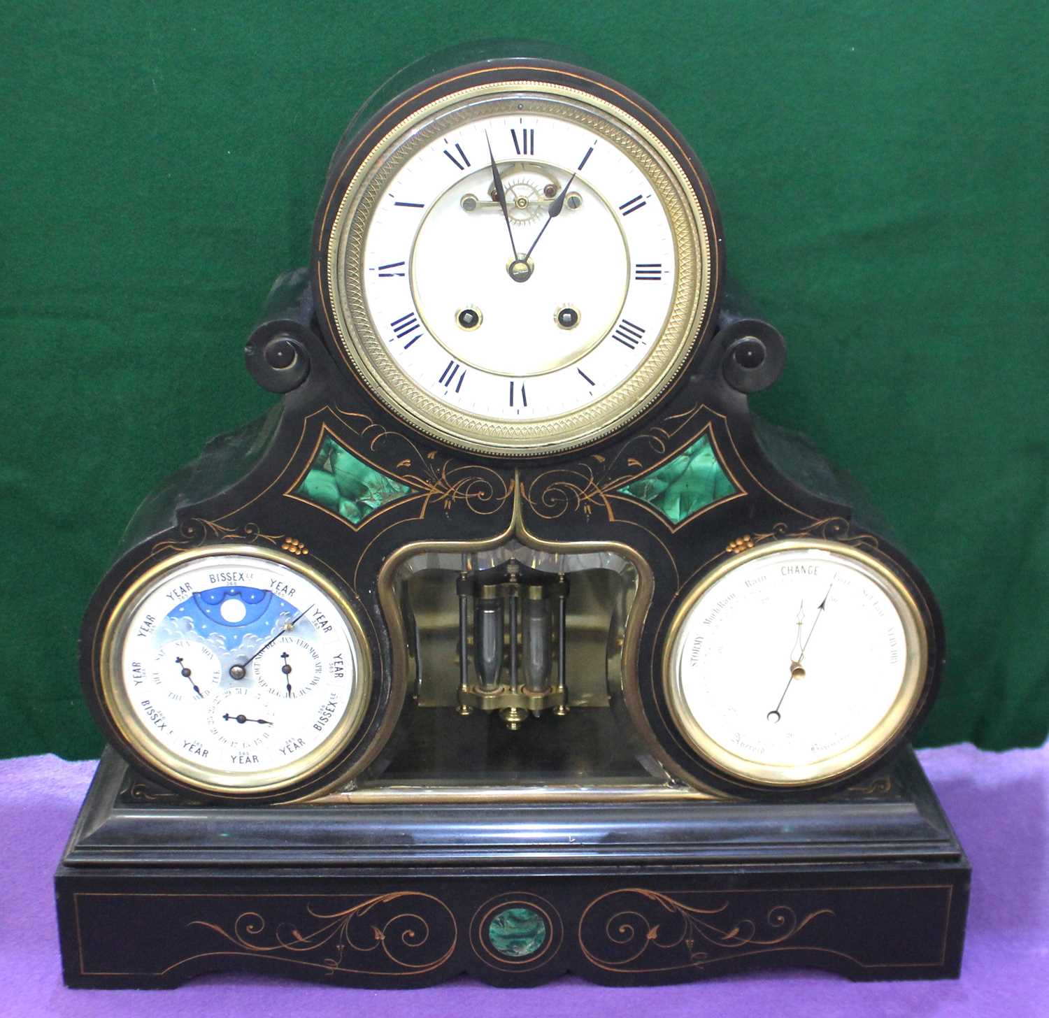 A late 19th century Belgium black marble and malachite inset calendar mantle clock, white enamel