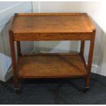 An oak tea trolley with pull out platform and under shelf on castors 71cm