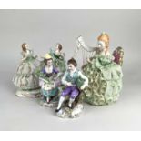 A pair of Sitzendorf porcelain figures of a seated gentleman and a lady, with Sitzendorf mark and '