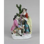 A Chelsea-style porcelain figure group of a gentleman and lady examining ribbons, gold anchor mark