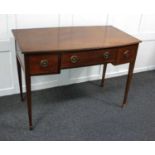 An Edwardian mahogany bowfront desk with an arrangement of three drawers on square tapered legs to