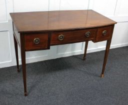 An Edwardian mahogany bowfront desk with an arrangement of three drawers on square tapered legs to