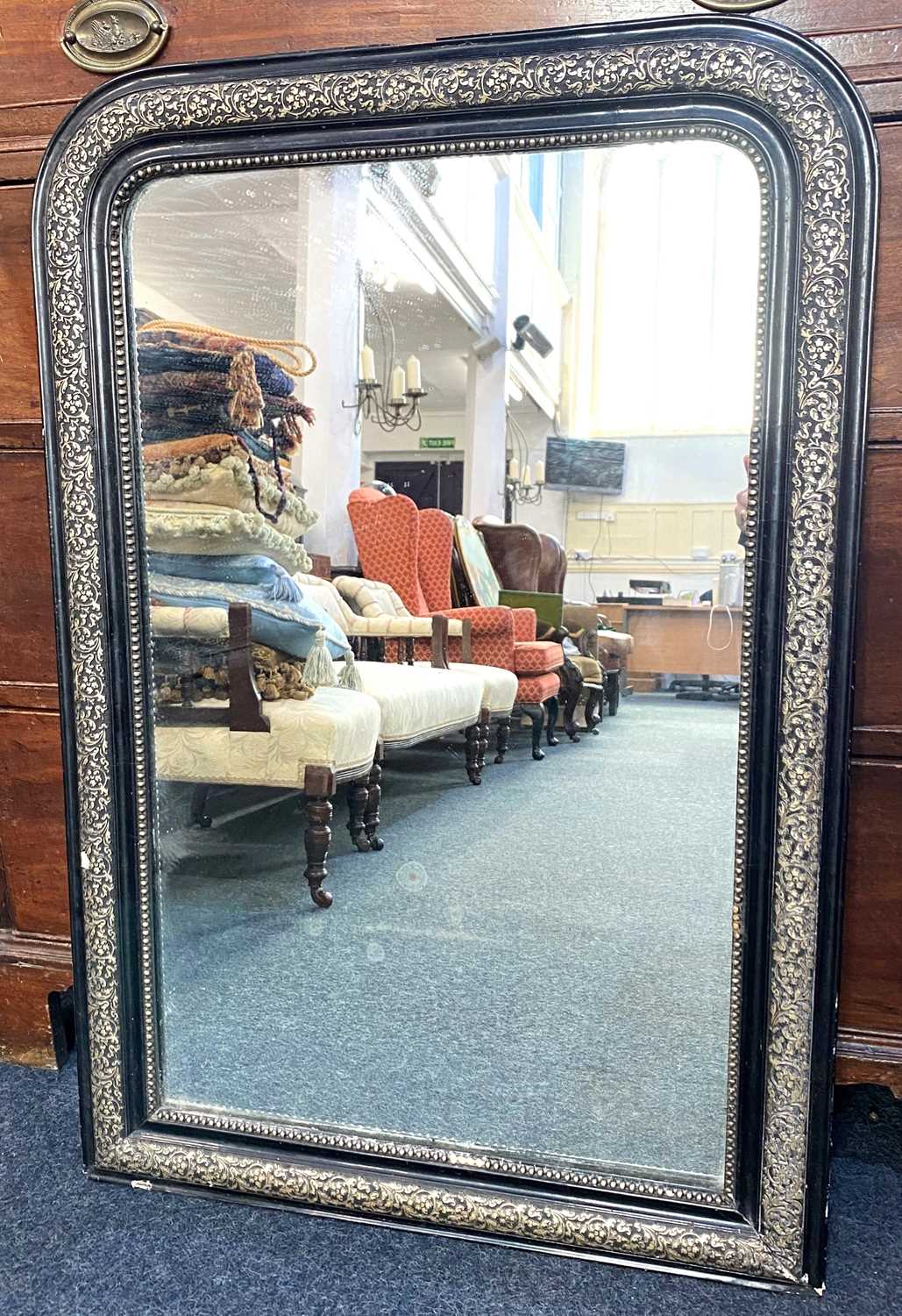 A black and gilt framed rectangular shaped wall mirror, with rounded corners 66cm by 97cm