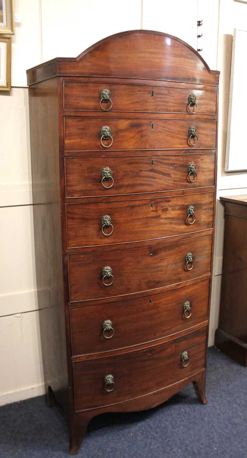 A 19th century mahogany bowfront chest of seven graduated drawers with brass lion mask ring