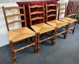 A set of four ladderback dining chairs with rush seats on block and turned supports