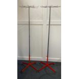 A pair of mid century coat stands in a modernist style, the chrome hooks and cylindrical columns