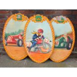 Three painted oval wooden signs possibly from a fairground, decorated with figures in racing cars