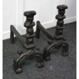 A pair of cast iron fire dogs in the form of busts on plinths, 47cm