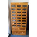 An early 20th century Haberdashery cabinet comprising of three rows of glass fronted small drawers