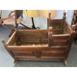 An 18th century wooden cradle with panelled sides and turned corner finials, on rocker supports,