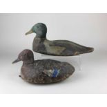 An early carved wooden decoy duck, with traces of original paintwork, underside with old metal