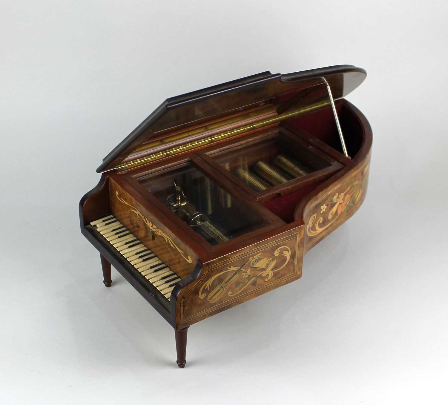 A music box modelled as a concert grand piano with label inscribed 'The Concert Music box of