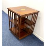 A small Edwardian style mahogany revolving bookcase, square top above slatted sides enclosing shelf,