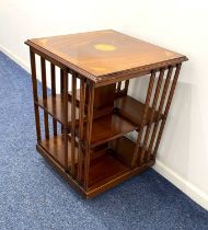 A small Edwardian style mahogany revolving bookcase, square top above slatted sides enclosing shelf,