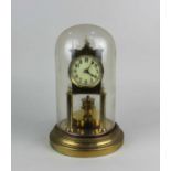 A gilt metal anniversary mantle clock under a glass dome on circular base, 29cm