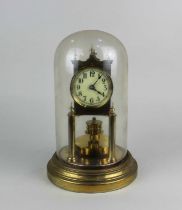 A gilt metal anniversary mantle clock under a glass dome on circular base, 29cm