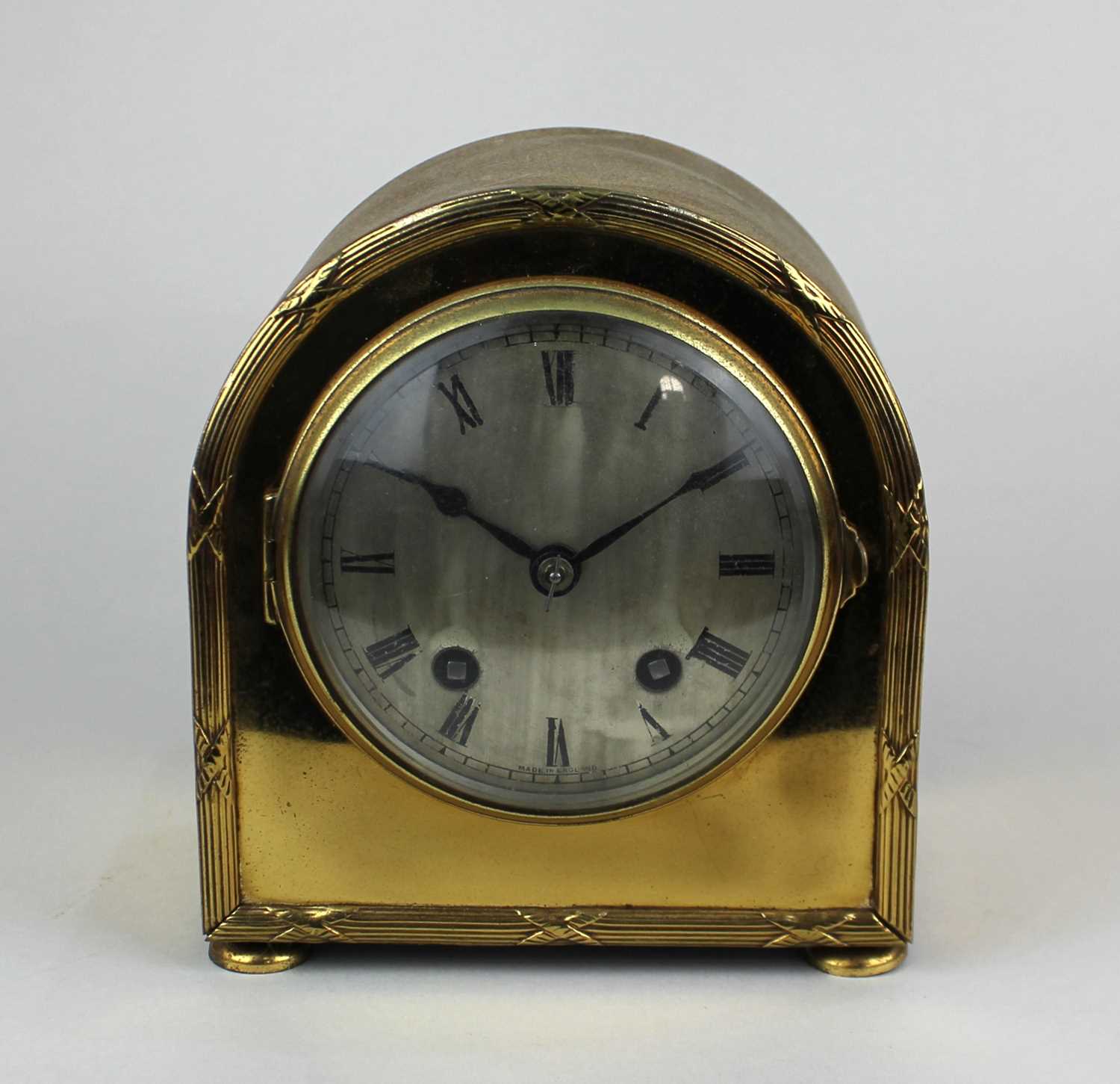 An early 20th century brass mantle clock with silvered dial and Roman numerals, in domed case, 14.