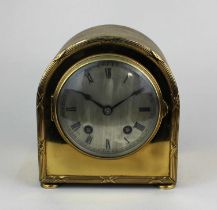 An early 20th century brass mantle clock with silvered dial and Roman numerals, in domed case, 14.