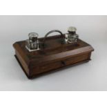 An oak and brass mounted desk tidy with two glass inkwells 28cm