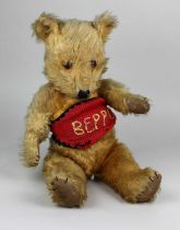 A vintage teddy bear, with golden plush, glass eyes, hand stitched nose, jointed limbs, 44cm high.