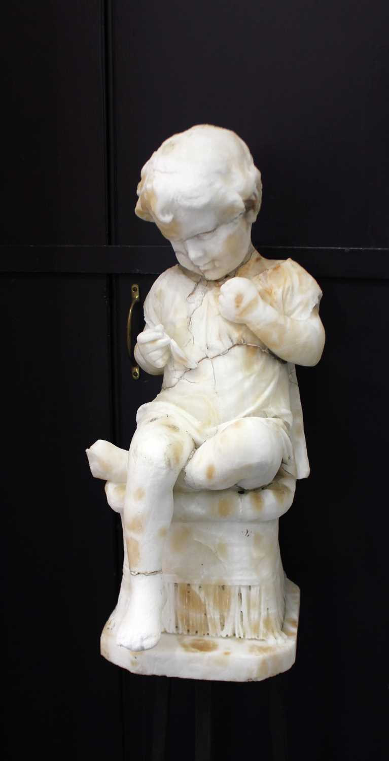 A carved alabaster figure of a seated child on metal stand 132cm overall (a/f)