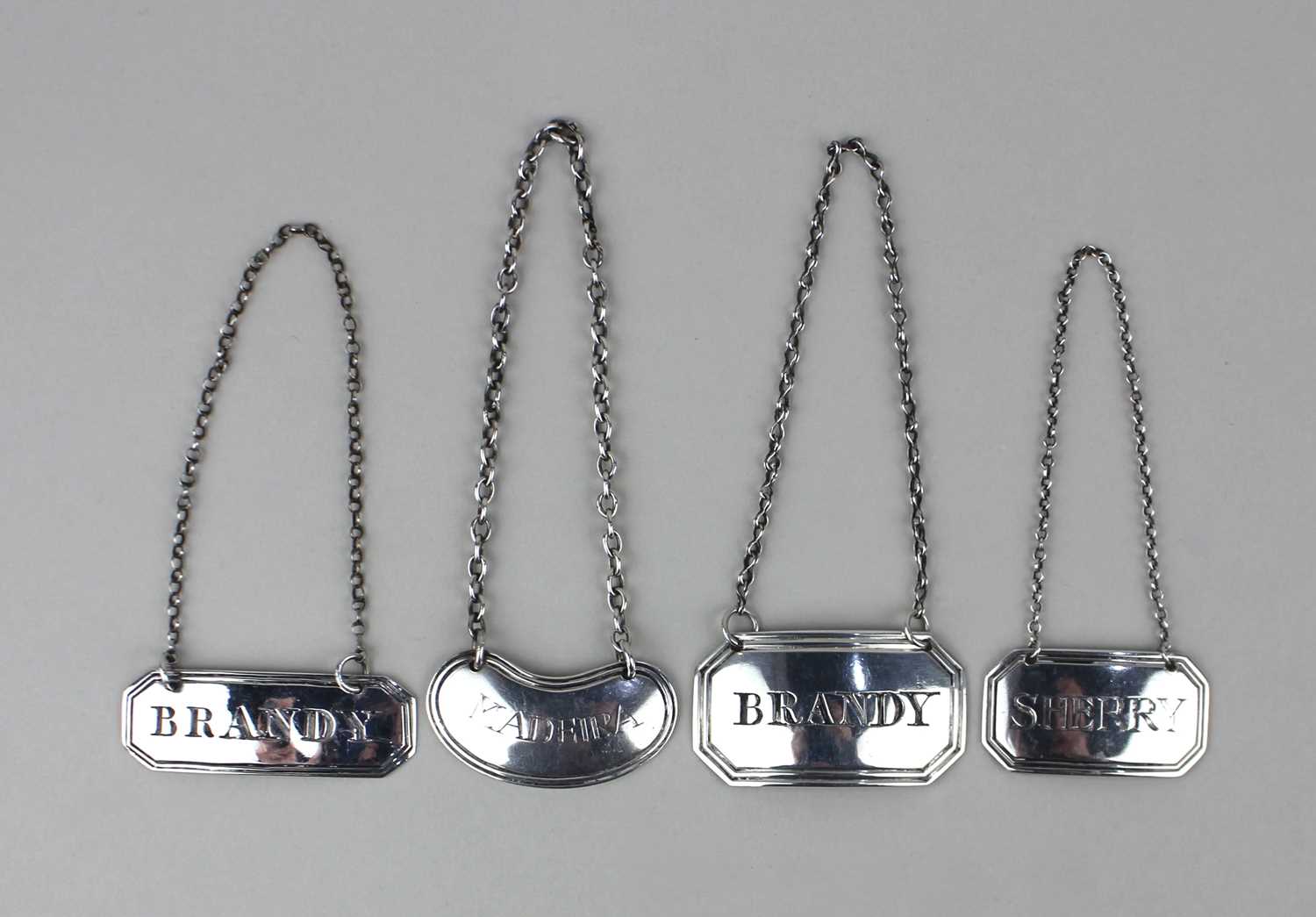Four silver decanter labels comprising Sherry, Madeira and two for Brandy, various dates and