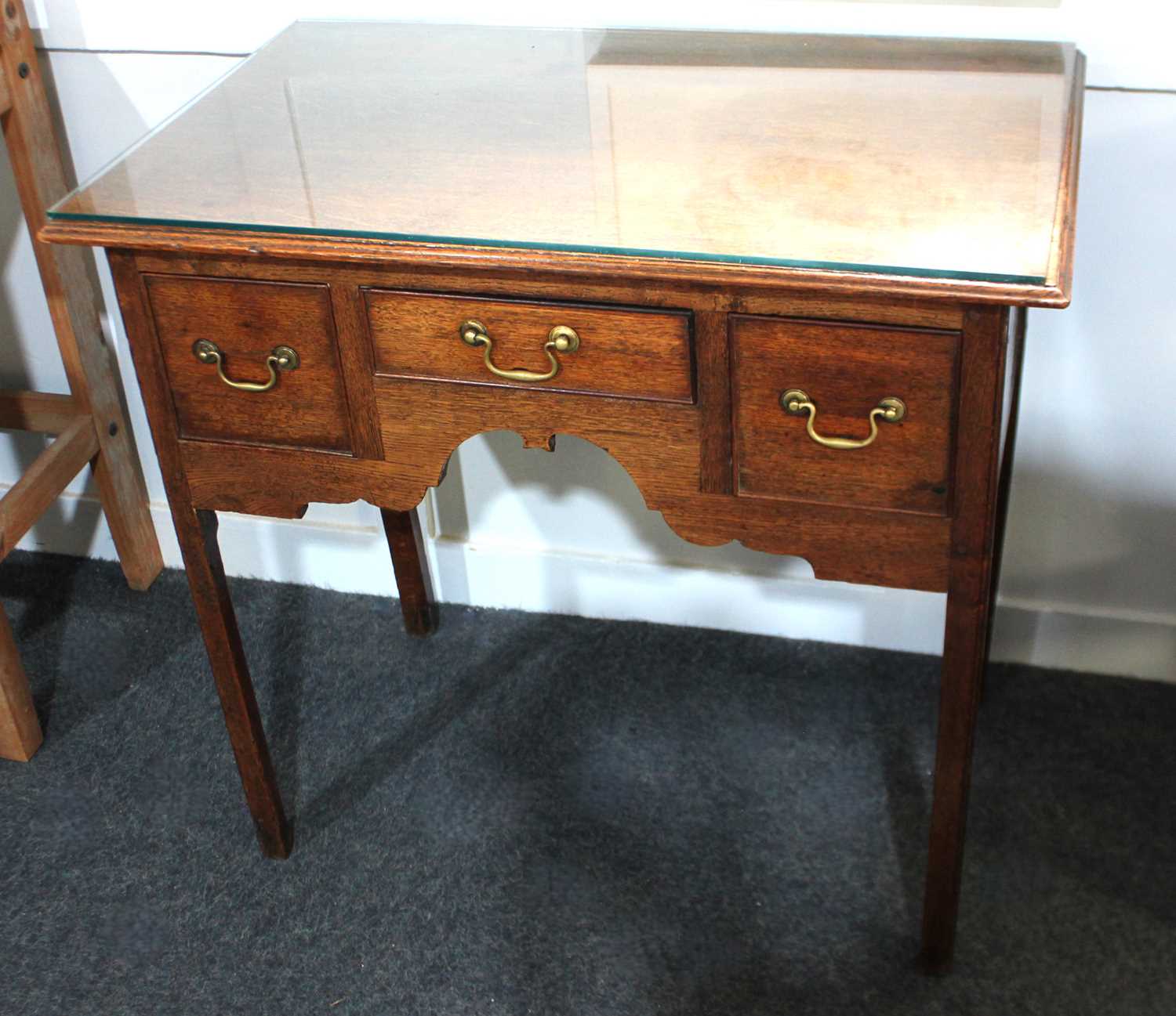 A George III oak kneehole side table rectangular top with moulded edge, three drawers with brass