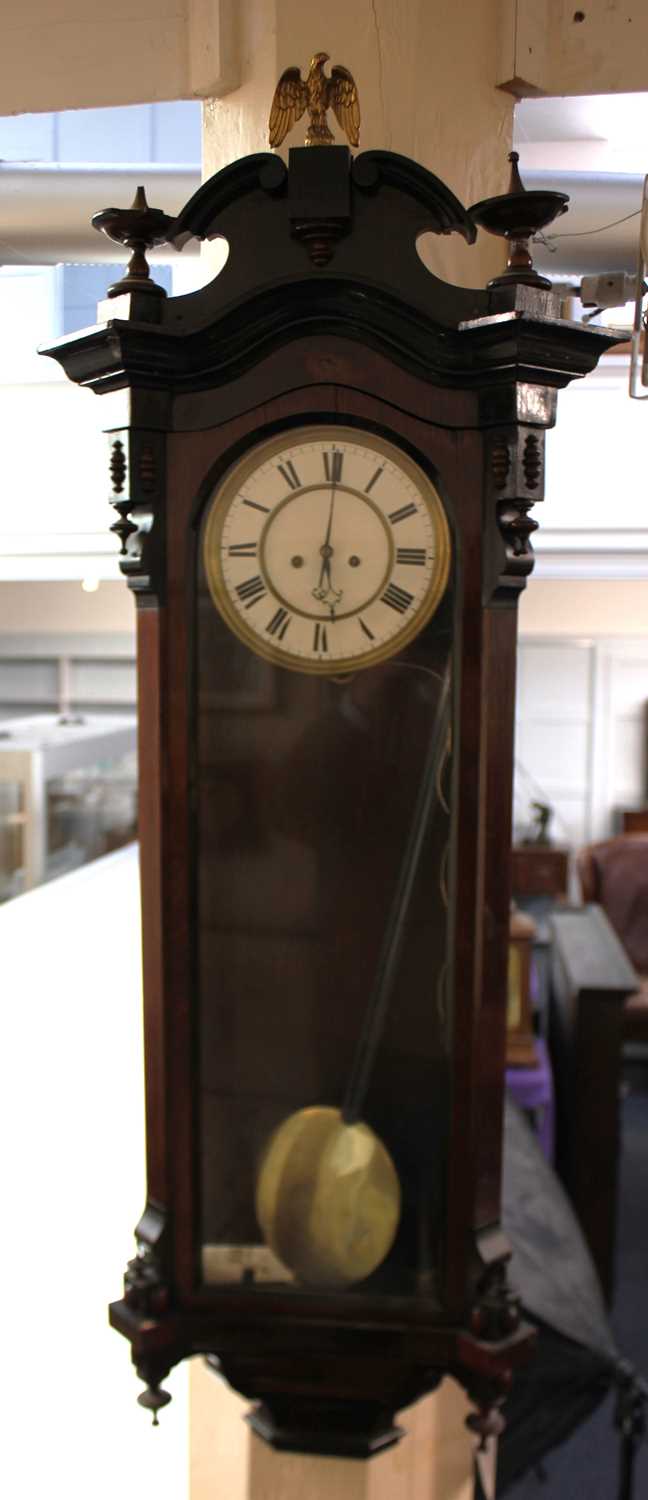 A Vienna wall clock with eagle surmount, 7 1/2 inch white enamel dial with Roman numerals, in glazed