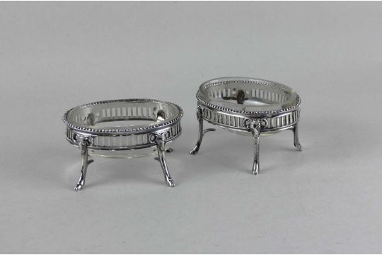 A pair of Continental silver salts of oval pierced design on rams mask supports with hoof feet,