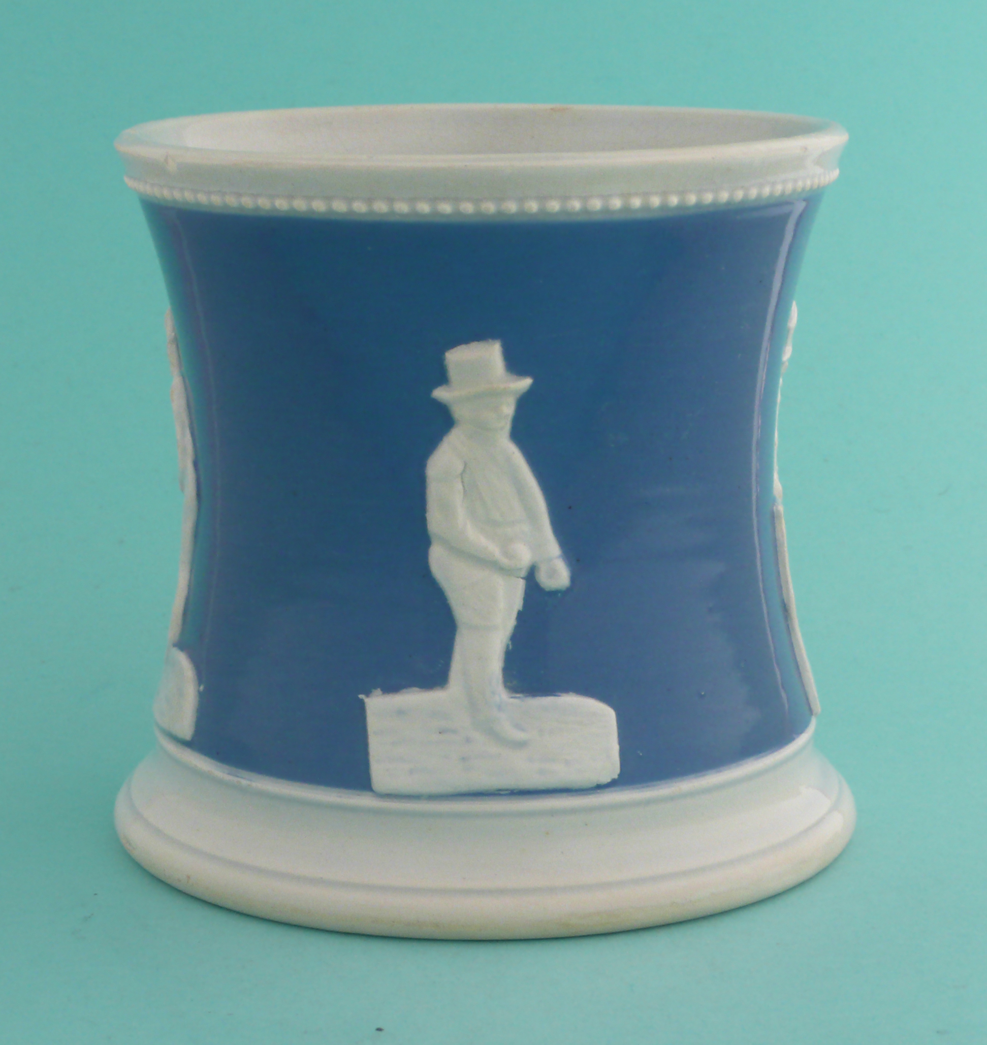 Cricket: a pottery mug the waisted body coloured blue and moulded in white with figures, circa 1850, - Image 3 of 5