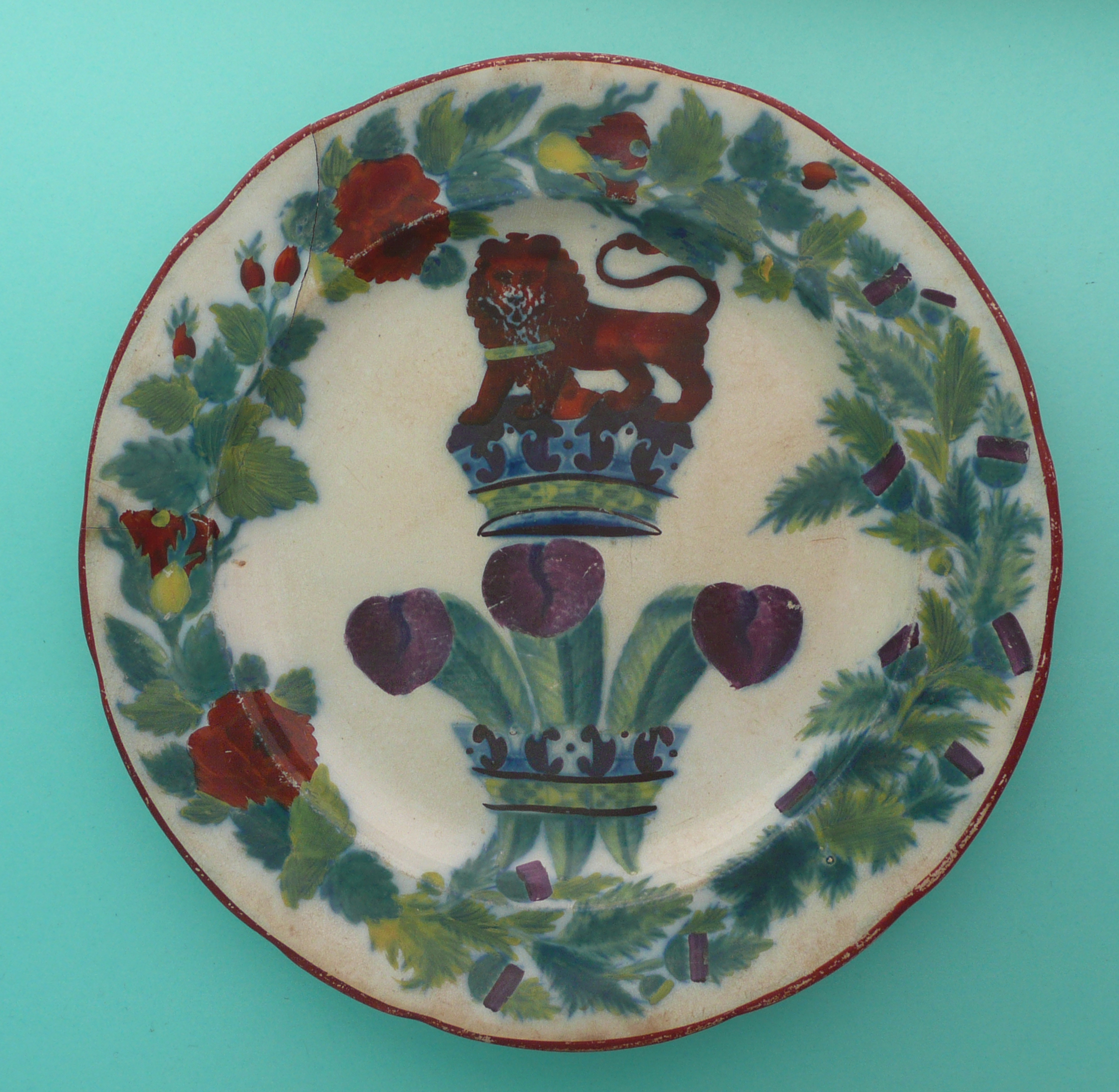 Prince Regent: an earthenware plate printed in green and enamelled in colours with feathers